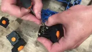 With a little precision screwdriver, get the black and blue cables out of the way.